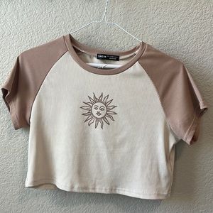 Brown t-shirt with a brown sun in the middle.